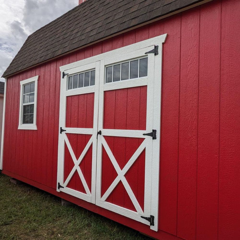 Red barn style shed with large double doors and loft