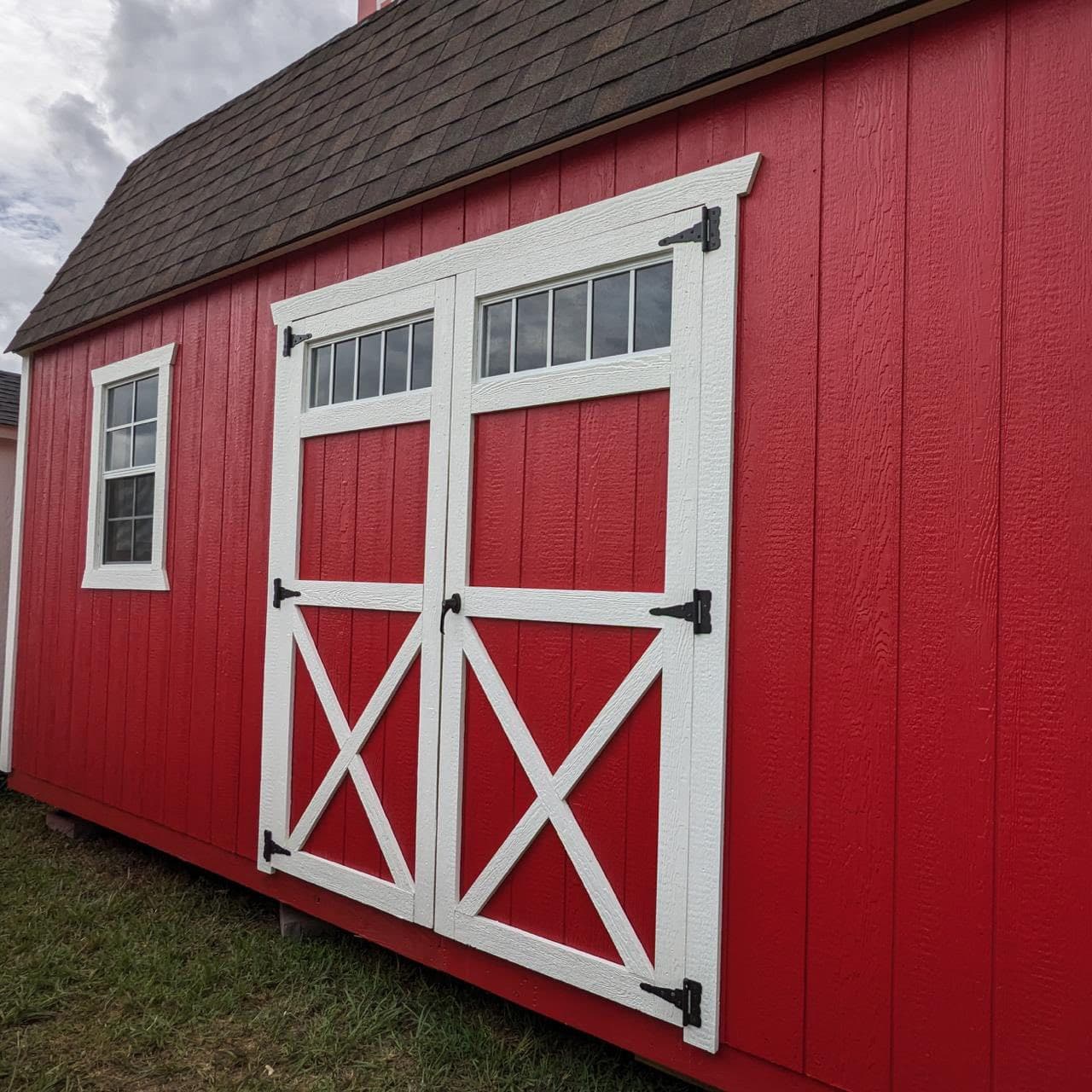 Red barn style shed with large double doors and loft