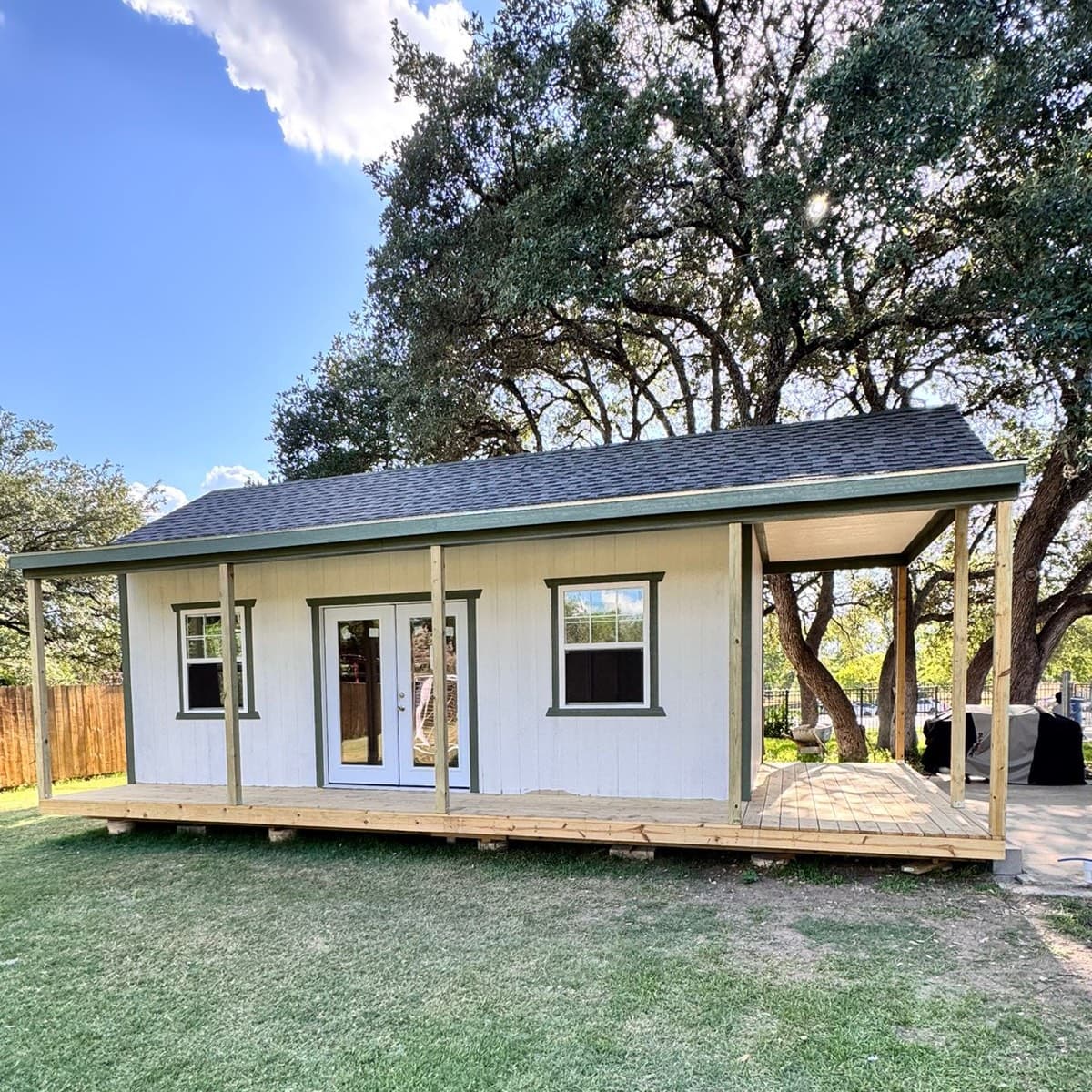 Wraparound porch shed with wooden porch and outdoor seating
